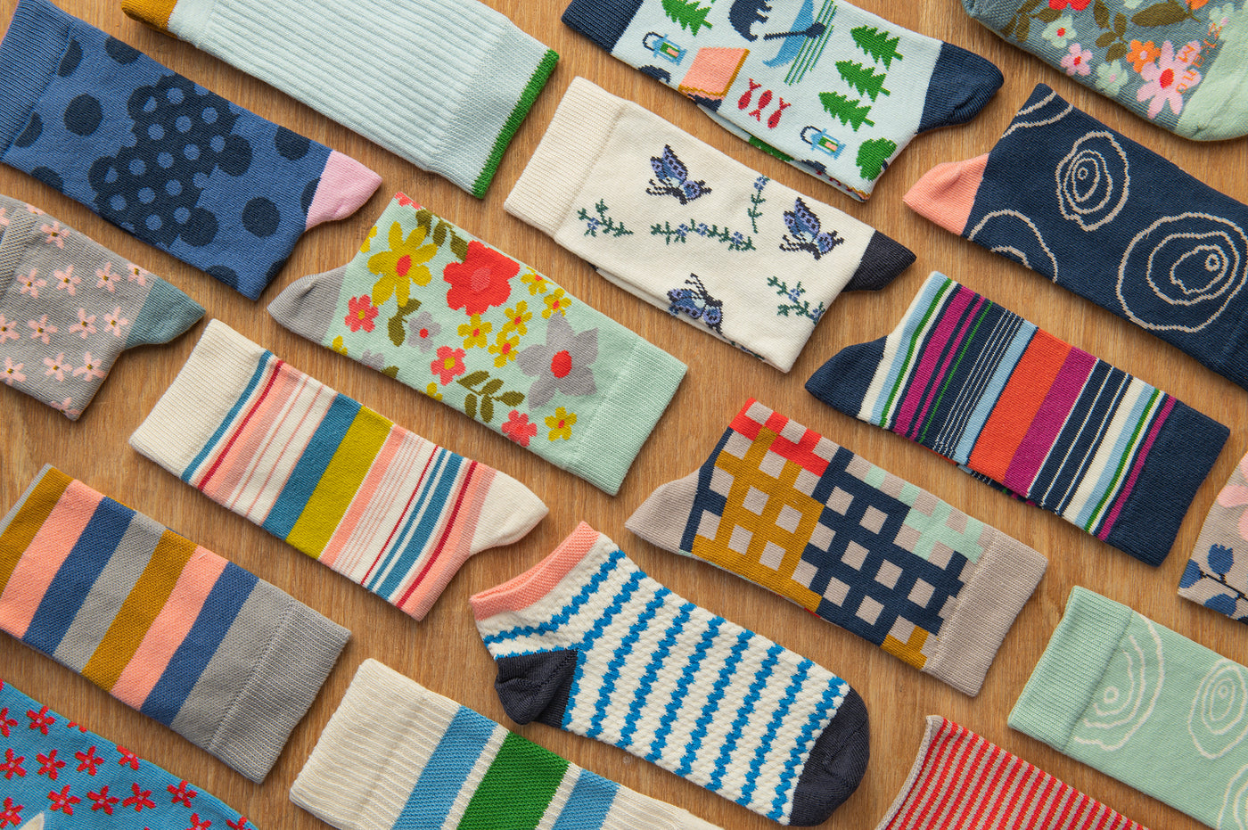 brightly patterned and striped organic cotton socks laying on a wooden surface