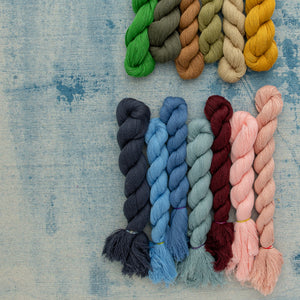 colorful twisted swatches of organic cotton on a denim blue surface 
