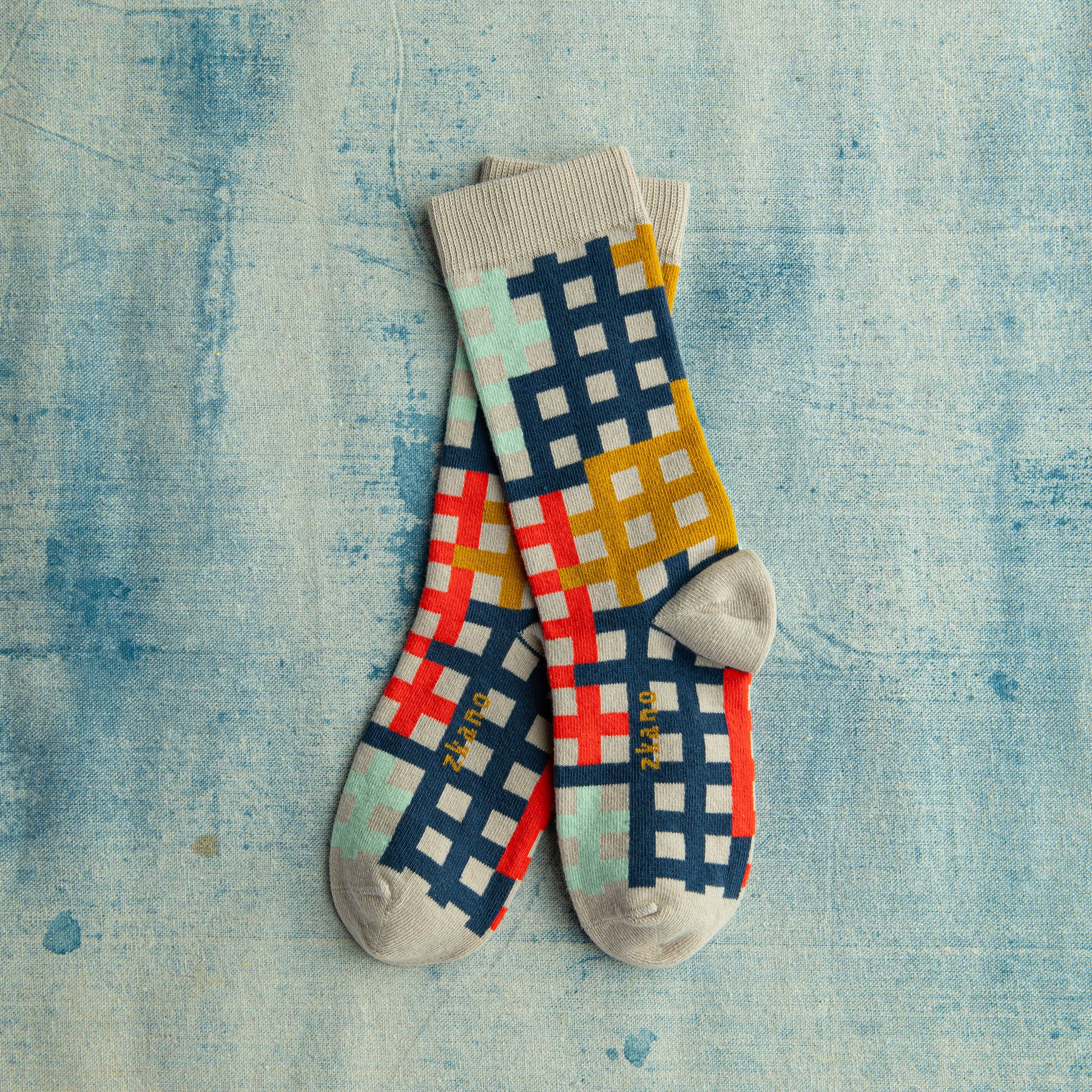 women's grid patterned organic cotton socks on a painted blue surface