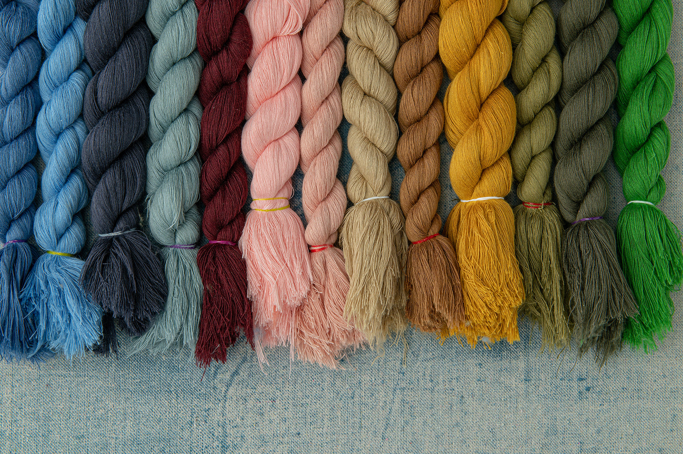 colorful twisted swatches of organic cotton on a denim blue surface 