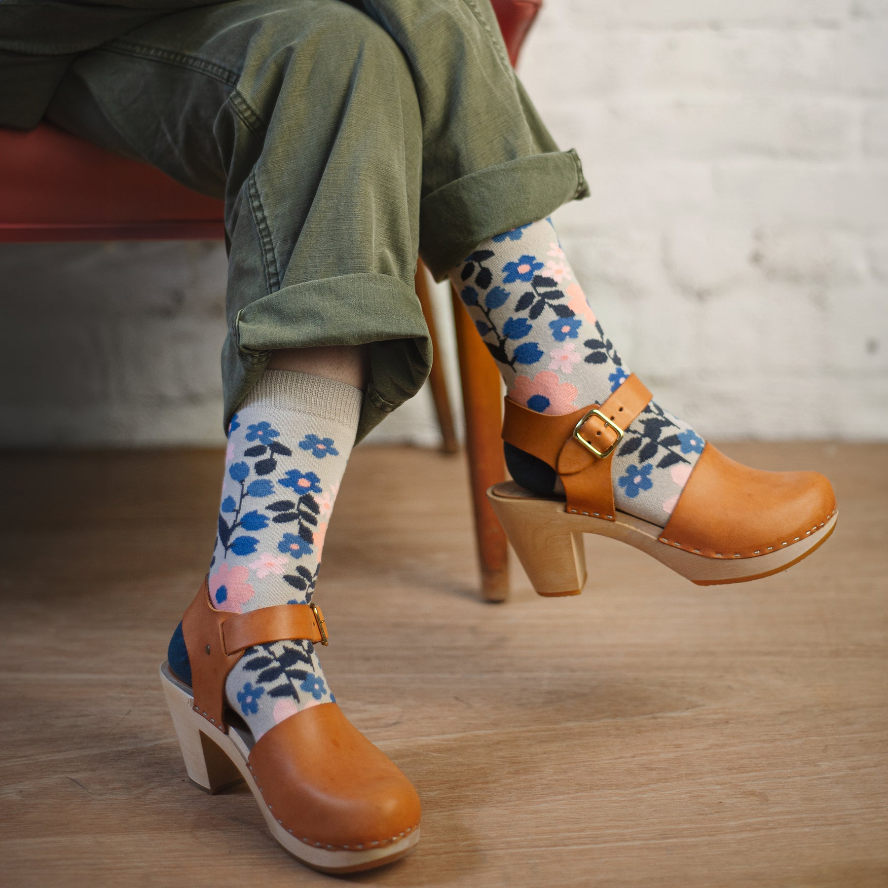woman wearing floral patterned organic cotton socks with cuffed pants and brown clogs
