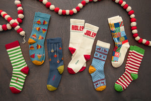 holiday patterned organic cotton socks laying on a dark wooden surface